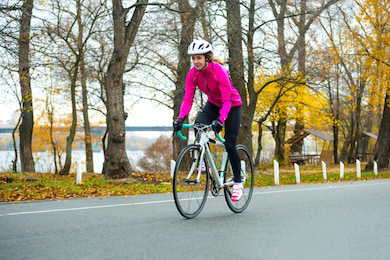 This bicyclist's hot pink jacket stands out against the orange and yellow in the background.