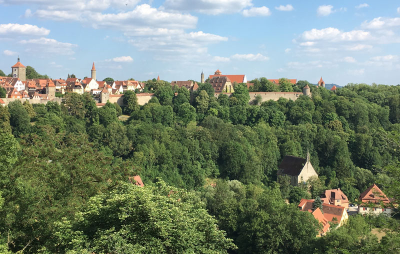 The red roofs of Rothenberg poke above the lush green forest.