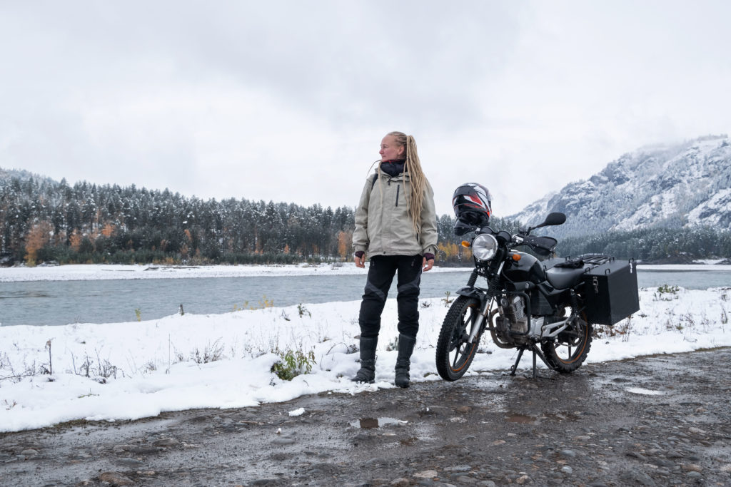 Woman next to motorcycle on mountainside, Yuasa Battery